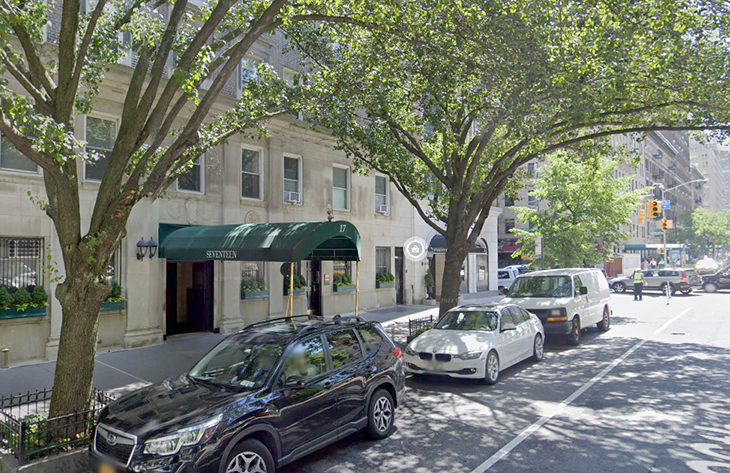 Street view of office building near traffic light and trees